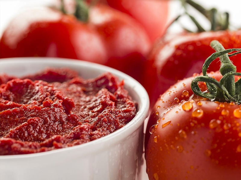 adding tomato paste to sauce